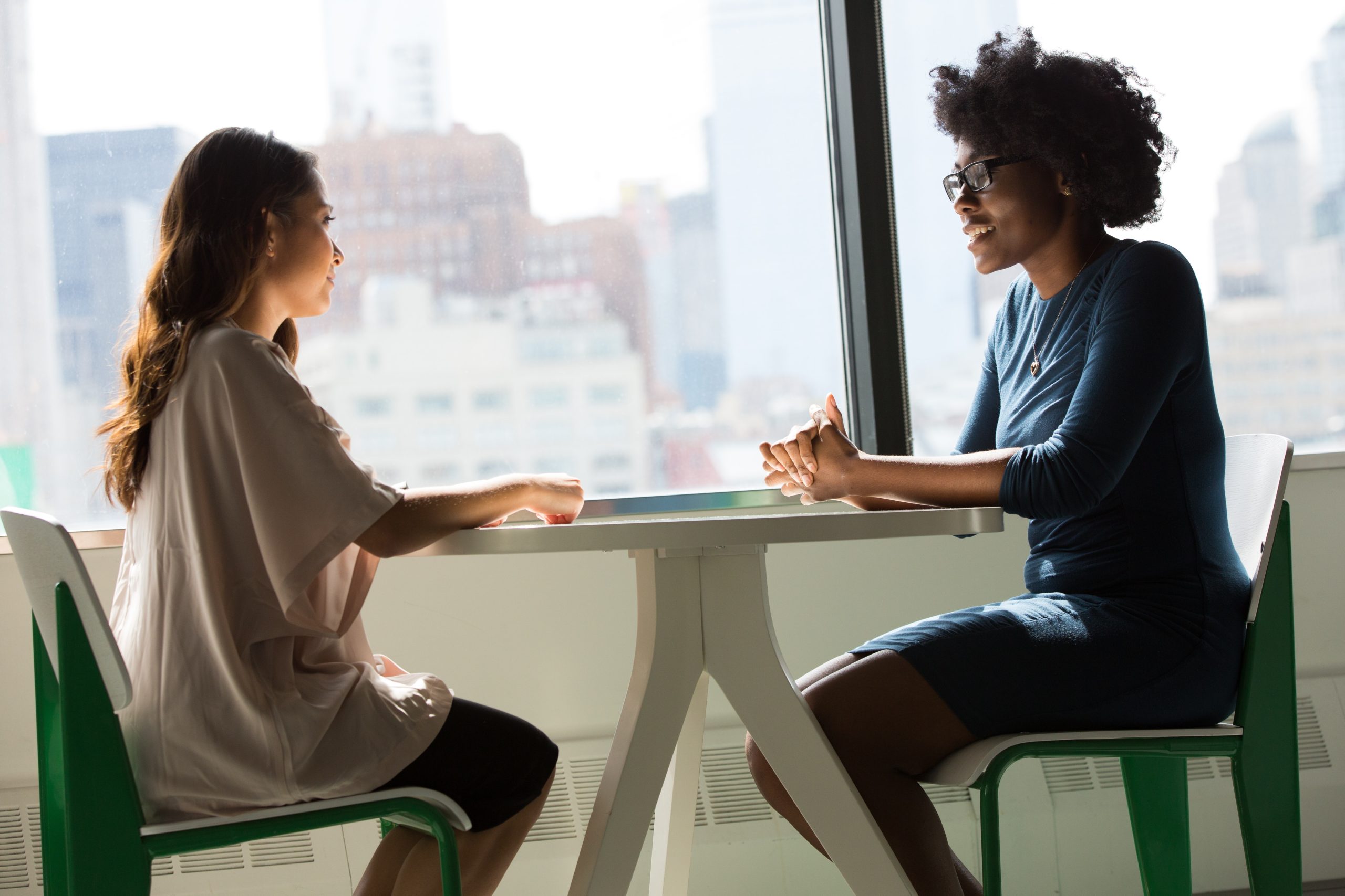 2 women chatting at table